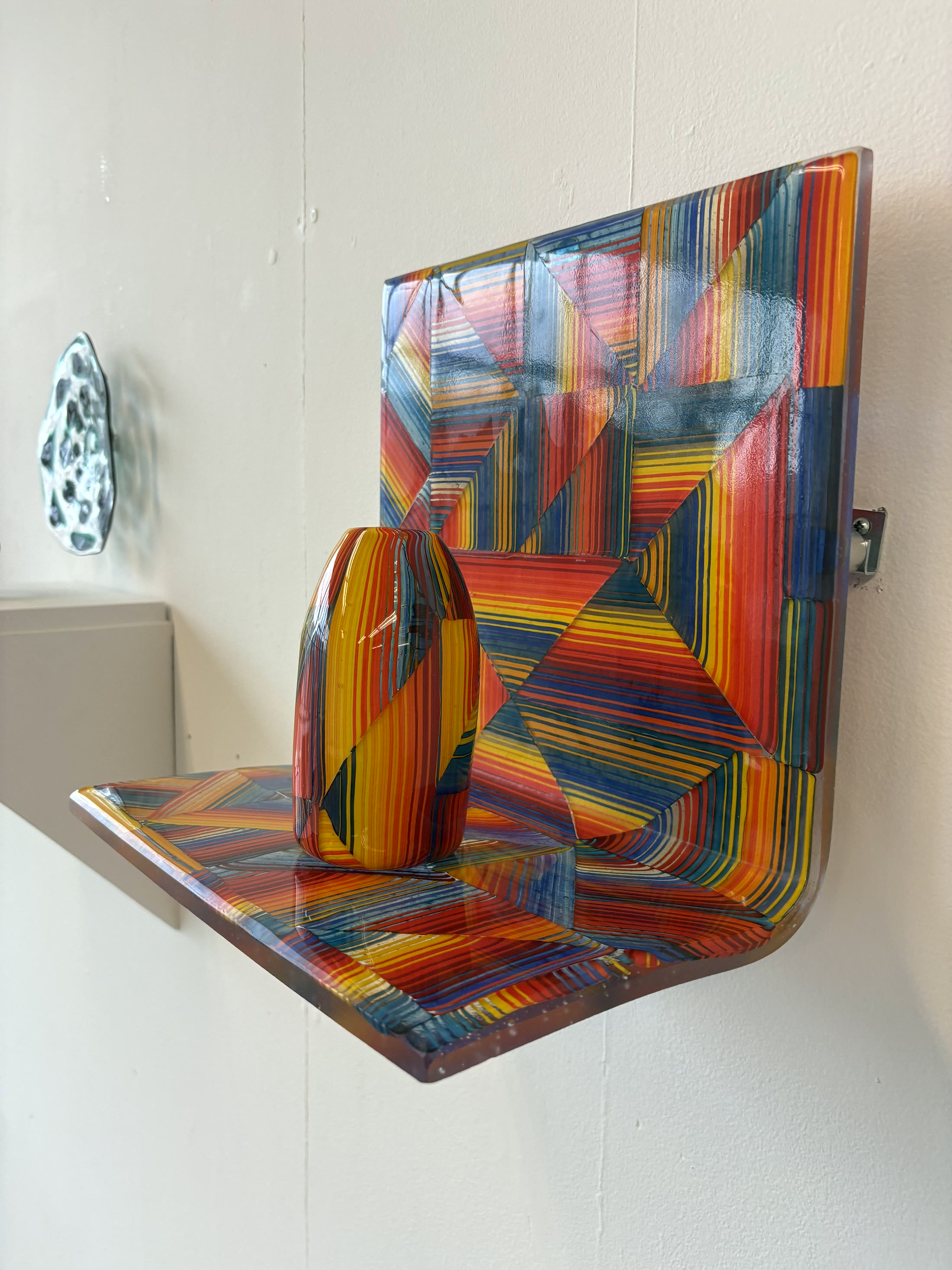 Colorful glass and metal wall work showing material composition